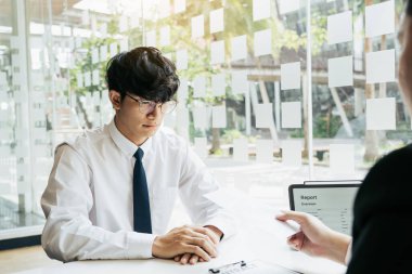 Erkek müdür çalışana istifa mektubu dağıtırken çalışanın işten çıkarılması hakkında konuşuyor ya da açıklama yapıyor..