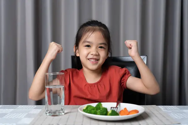 子供は野菜や栄養価の高い食べ物の強さを示しています ロイヤリティフリーのストック写真