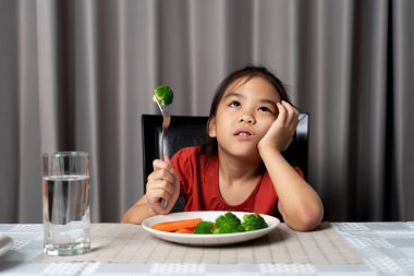 Küçük tatlı kız sağlıklı sebze yemeyi reddediyor. Çocuklar sebze yemeyi sevmez..