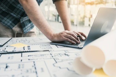 Yeni projede çalışan ve dizüstü bilgisayar kullanan mimar.