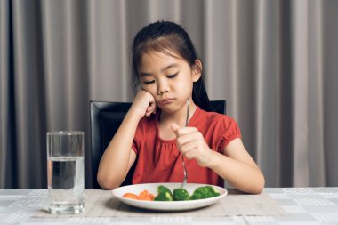 Küçük tatlı kız sağlıklı sebze yemeyi reddediyor. Çocuklar sebze yemeyi sevmez..