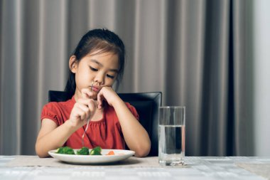Küçük tatlı kız sağlıklı sebze yemeyi reddediyor. Çocuklar sebze yemeyi sevmez..