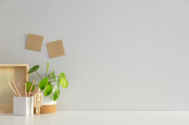 Ofiste malzeme ve duvar fotokopi alanı olan bir masa. Asgari çalışma alanı.