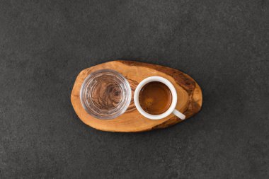 Bir fincan sıcak espresso kahve ve bardakla koyu sehpada, özel kahve konsepti..