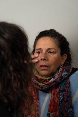 Bir hastanın göz protezine nazikçe uyan göz doktoru, destekleyici bir sağlık ortamında hassasiyet ve bakım göstermektedir.