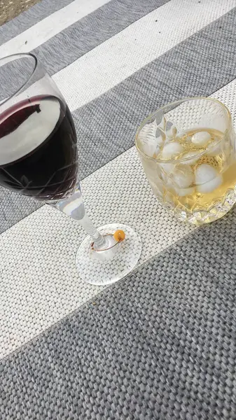 İki ferahlatıcı yaz içkisi çizgili bir açık hava halısında güneşli bir günün rahat titreşimlerini yakalıyor. Parlak, esintili ve rahatlatıcı anlar için mükemmel ya da ılık havalarda sıradan buluşmalar için..