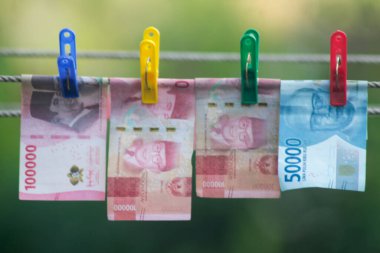Para aklama konsepti. Rupiah faturaları çamaşır ipine asılı. Para aklamanın sembolü. Uzayın yumuşak odaklanmasını kopyala Para çamaşır ipinde.