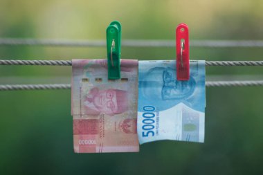 Para aklama konsepti. Rupiah faturaları çamaşır ipine asılı. Para aklamanın sembolü. Uzayın yumuşak odaklanmasını kopyala Para çamaşır ipinde.