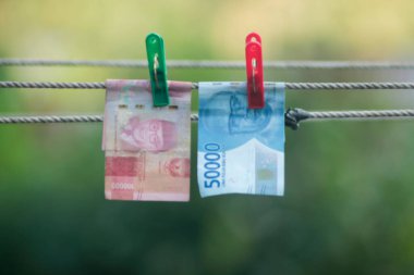Para aklama konsepti. Rupiah faturaları çamaşır ipine asılı. Para aklamanın sembolü. Uzayın yumuşak odaklanmasını kopyala Para çamaşır ipinde.