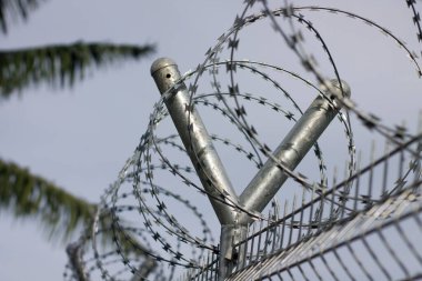 Dikenli tel. Dikenli tel çit mavi gökyüzü ile üzerinde