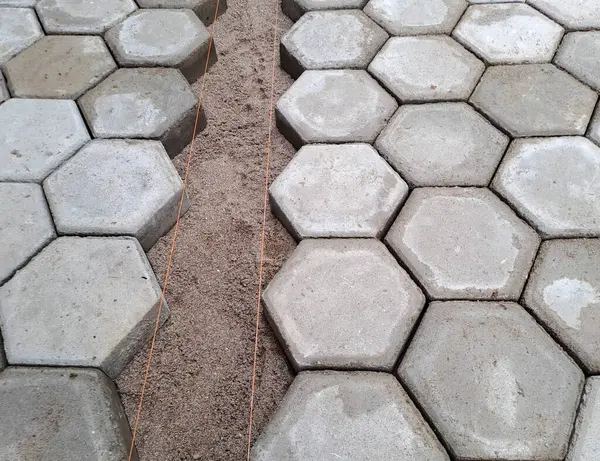 Altıgen kaldırım döşemesi. İnşaat aletleri ve detaylar, plastik çekiçle döşeme. Altıgen asfalt döşeme, kaldırım döşeme
