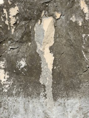 Dikey çatlak taş yüzey dokusu. Düz olmayan yüzeyi ve yıpranmış aşınma izleri olan dikey çatlak taşlara yakın çekim. Doku geçmişi ve tasarım kullanımı için mükemmel. Yüksek kalite fotoğraf