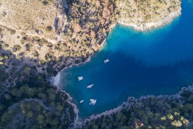 Açık Mavi Sularda Çapalı Tekneler. Yeşillik ve canlı deniz renkleriyle çevrili Türk yat limanı mükemmel bir yaz kaçışı. Yüksek kalite fotoğraf