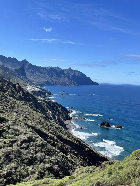 Anaga Tepesi 'nden görüldüğü gibi Tenerifes' in kuzey kıyı şeridini geniş açıdan görebiliyoruz. Engebeli volkanik kayalıklar, kıyı şeridi boyunca dalgalar ve kıyıda yuva yapmış küçük bir köyle Atlantik Okyanusu 'na iniyor..