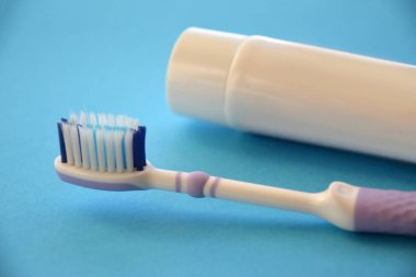 Mavi kağıtta diş fırçası ve diş macunu yakın plan.