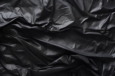 Siyah selofan çöp torbası dokusunun işlenmiş kolajı. Pankart, arkaplan veya 3B haritalama için doku