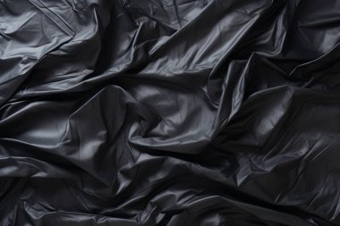 Siyah selofan çöp torbası dokusunun işlenmiş kolajı. Pankart, arkaplan veya 3B haritalama için doku