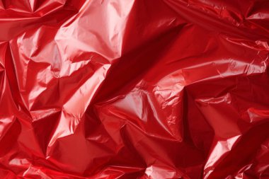 İşlenmiş kırmızı plastik selofan yüzey dokusu kolajı. Pankart, arkaplan veya 3B haritalama için doku