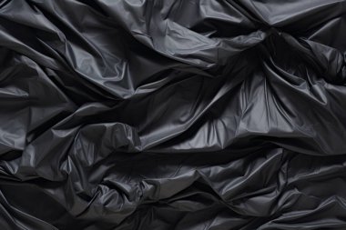 Siyah selofan çöp torbası dokusunun işlenmiş kolajı. Pankart, arkaplan veya 3B haritalama için doku