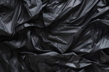 Siyah selofan çöp torbası dokusunun işlenmiş kolajı. Pankart, arkaplan veya 3B haritalama için doku