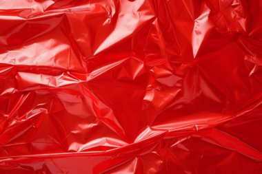 İşlenmiş kırmızı plastik selofan yüzey dokusu kolajı. Pankart, arkaplan veya 3B haritalama için doku