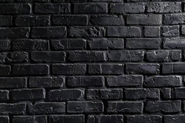 Eski tuğla duvarın resmi siyah renge boyanmış. Yakın plan. Arkaplan veya haritalama için arkaplan dokusu