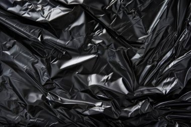 Buruşmuş siyah politen plastik ambalaj kağıdının fotoğrafı. Arkaplan veya haritalama için arkaplan dokusu