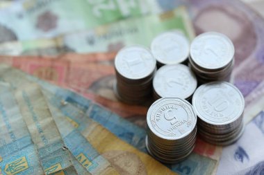 Birkaç yığın Ukrayna parası eski Hryvnia banknotlarının üzerinde yatıyor.
