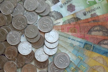 Ukraine money coins lying on mixed hryvnia banknotes, background. finance concept