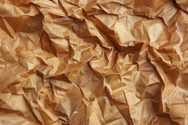Buruşuk kahverengi kağıdın fotoğrafı. Kapatın. Arkaplan veya haritalama için arkaplan dokusu