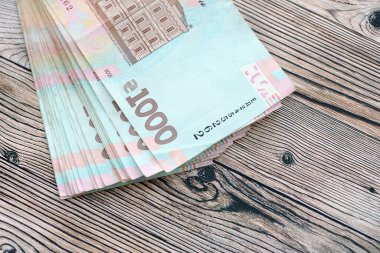 Ahşap arka planda modern tasarımı olan büyük miktarda Ukrayna yapımı 100 Hryvnia para faturası. Finansal konsept, iş ücretleri