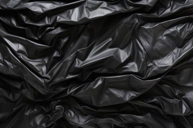 Siyah selofan çöp torbası dokusunun işlenmiş kolajı. Pankart, arkaplan veya 3B haritalama için doku