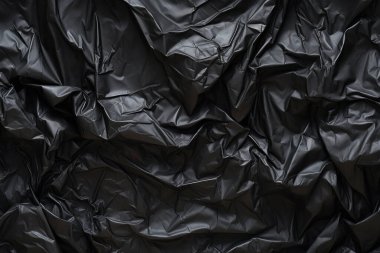 Siyah selofan çöp torbası dokusunun işlenmiş kolajı. Pankart, arkaplan veya 3B haritalama için doku