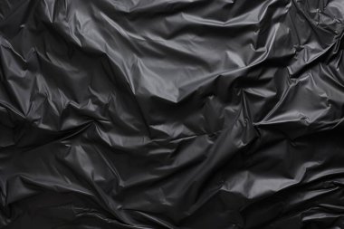 Siyah selofan çöp torbası dokusunun işlenmiş kolajı. Pankart, arkaplan veya 3B haritalama için doku