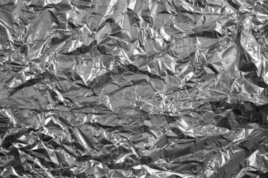 Parlak metalden işlenmiş gümüş folyo buruşmuş ambalaj malzemesi dokusu arka planı.