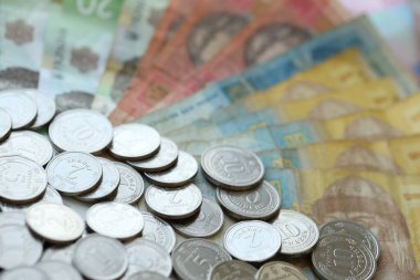 Ukraine money coins lying on mixed hryvnia banknotes, background. finance concept