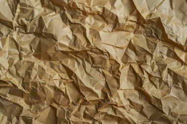 Buruşuk kahverengi kağıdın fotoğrafı. Kapatın. Arkaplan veya haritalama için arkaplan dokusu