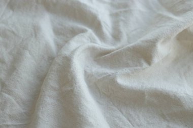 Arka plan olarak beyaz renkli gri tekstil peçetesi. Katlanmış dekoratif mutfak pamuğu havlusu kapat.