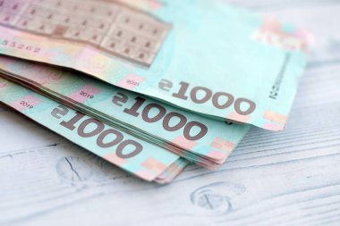 Beyaz ahşap masa üzerinde modern tasarımı olan büyük miktarda Ukrayna yapımı 100 Hryvnia para faturası. Finansal konsept, iş ücretleri