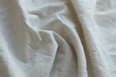 Arka plan olarak beyaz renkli gri tekstil peçetesi. Katlanmış dekoratif mutfak pamuğu havlusu kapat.