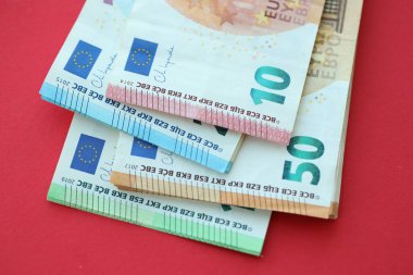Büyük meblağda yüz, yirmi, on ve elli euro. Kırmızı arka planda. Yakın plan.