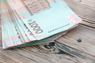 Ahşap arka planda modern tasarımı olan büyük miktarda Ukrayna yapımı 100 Hryvnia para faturası. Finansal konsept, iş ücretleri