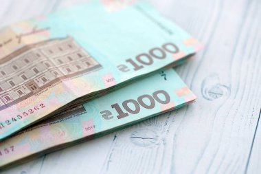 Beyaz ahşap masa üzerinde modern tasarımı olan büyük miktarda Ukrayna yapımı 100 Hryvnia para faturası. Finansal konsept, iş ücretleri