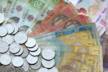 Ukraine money coins lying on mixed hryvnia banknotes, background. finance concept