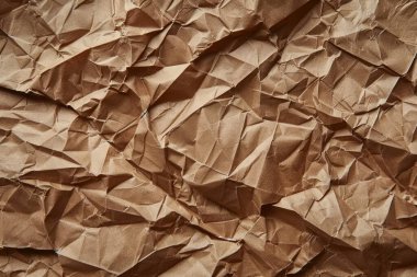 Buruşuk kahverengi kağıdın fotoğrafı. Kapatın. Arkaplan veya haritalama için arkaplan dokusu