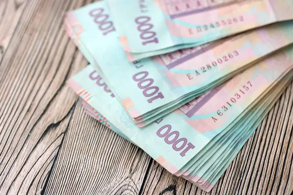Ahşap arka planda modern tasarımı olan büyük miktarda Ukrayna yapımı 100 Hryvnia para faturası. Finansal konsept, iş ücretleri