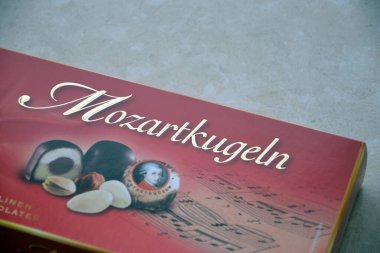 KHARKIV, UKRAINE - 2 Şubat 2024 Kırmızı Mozart Kugeln şekerleri kutusu mermer arka planda yakın plan