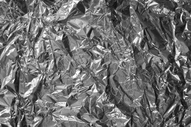 Parlak metalden işlenmiş gümüş folyo buruşmuş ambalaj malzemesi dokusu arka planı.