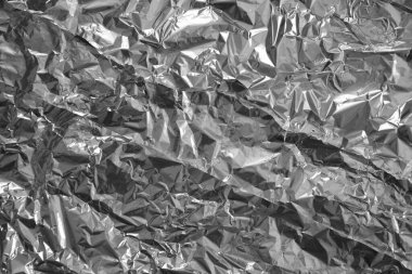 Parlak metalden işlenmiş gümüş folyo buruşmuş ambalaj malzemesi dokusu arka planı.