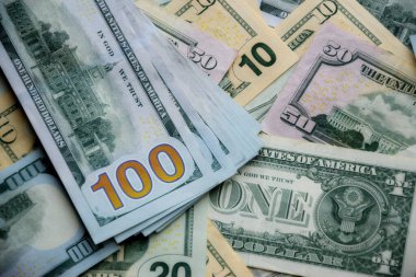 Masada farklı adaylıklarda büyük miktarlarda Amerikan doları var. Doğal ışık altında birçok dolarlık banknotlar.